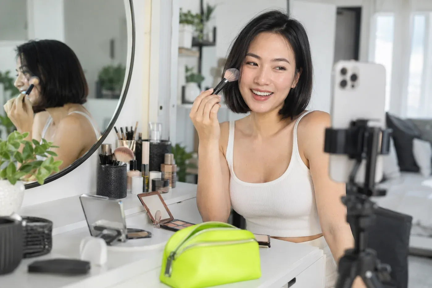 A beauty creator recording a makeup tutorial at a white vanity